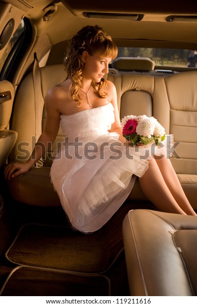 Bride is sitting in limousine and getting ready to\
get out