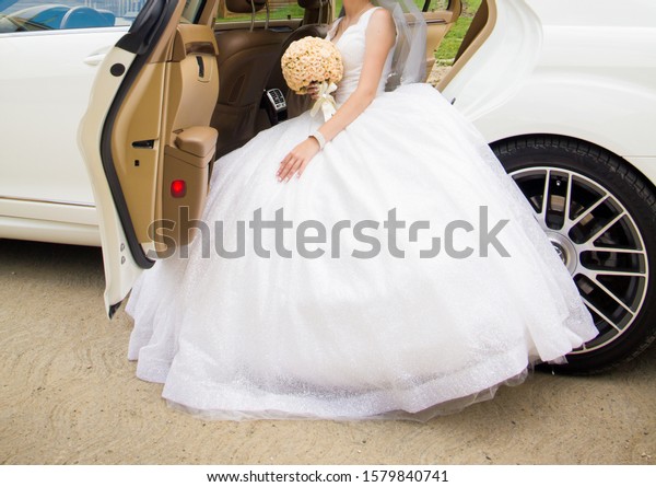 The bride is sitting in\
a wedding car