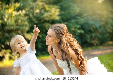 Bride And Smartly Dressed Girl Playing In The Park. Mother And Daughter. Problem Of Child When Mother Is In Second Marriage