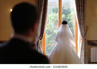 Bride standing in front of the window of an old building