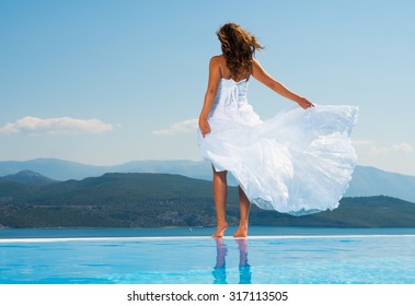 Bride Standing On The Edge On The Infinity Pool In Greece