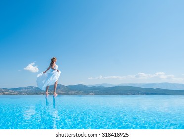 Bride Standing On The Edge On The Infinity Pool In Greece