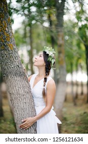 Bride stands by the tree