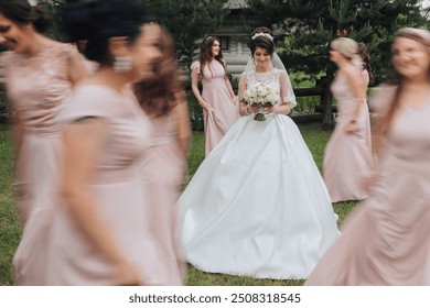 A bride is surrounded by her bridesmaids in a wedding party. The bride is wearing a white dress and holding a bouquet - Powered by Shutterstock