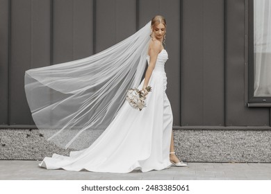 A bride is walking down a street with a white veil and a bouquet of flowers. The scene is set in a city, and the bride is wearing a white dress - Powered by Shutterstock