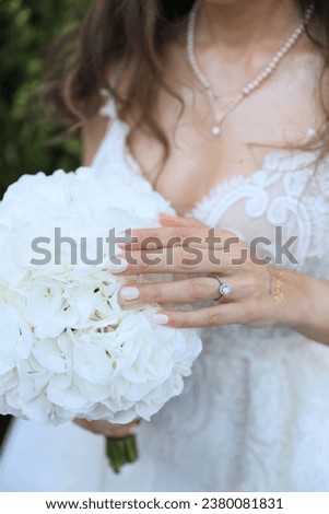Bride wearing wedding ring engagement. Close-up. The bride is holding her flower in her hand.