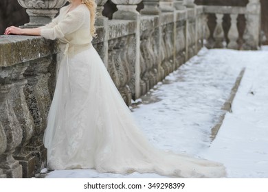 Bride In A Wedding Dress And A Fur Coat Fur Winter Walks In The Garden Near The Castle Before The Ceremony