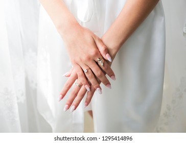 Bride in white clothes near the window. Beautiful manicure. Elegant nails. Golden rings. Wedding jewellery. - Shutterstock ID 1295414896