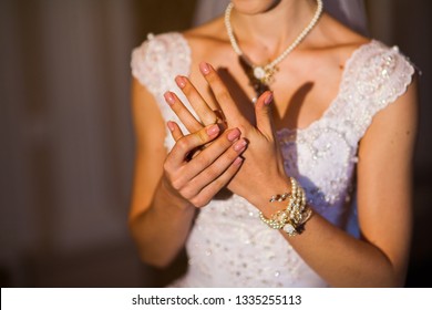 bride in white dress with cleavage straightens her hand ring close-up
