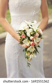 Bride In White Dress Holds A Beautiful Bouquet Cascade