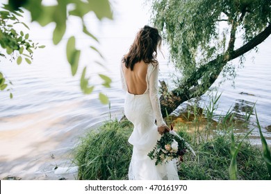 bride in a white dress walking in the woods by the sea beach. wedding concept