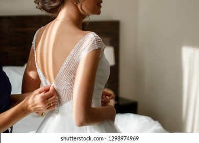 bride zipping up her wedding dress
