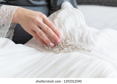 Bride's Hand Touching Details Of Her Wedding Dress. Simple French Manicure