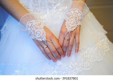 Bride's Hands In Fishnet Gloves On Wedding Dress Background