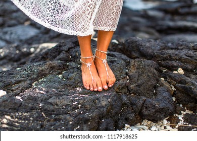 A Bride's Jewelry Adorned Feet On Lava Rock