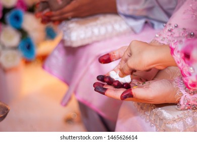 Brides Maids Or Woman Cleaning Bride’s Hand Or Another Woman At Pouring Blessing Ceremony In Borneo Malay Wedding With Soft Focus Surrounds.