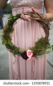 Bridesmaid Holding A Grape Vine Wreath With Greenery And Pink Roses In Lieu Of A Traditional Floral Bridesmaid Bouquet: Bridesmaid Bouquet Alternatives