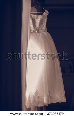 bridesmaid tying bow on wedding dress.