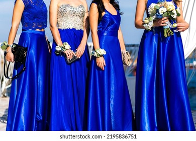 Bridesmaids with flowers stand at the wedding ceremony.