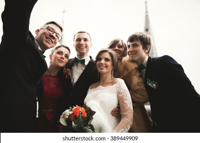 Bridesmaids, groomsmen and wedding couple making selfie with panoramic view of the city - Powered by Shutterstock