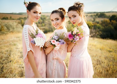 bridesmaids in pink dresses with bouquets