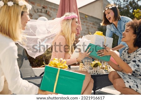 Bride-to-be is showered with love and gifts from her cherished friends. Gathered around her, the group exudes excitement and anticipation, eager to present their thoughtful gestures. [[stock_photo]] © 