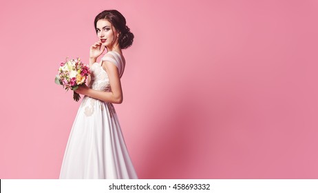 Bride.Young fashion model with perfect skin and make up, beige background, curly hair, flowers in hair