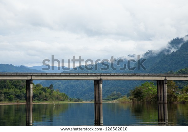 Bridge across the river. The mist covered\
mountains in the\
background.