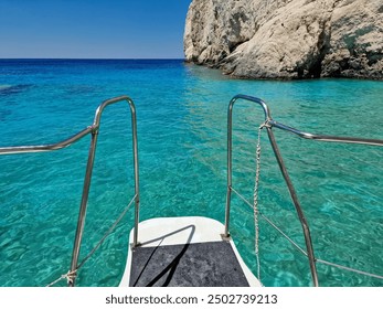 The bridge at the bow of the excursion boat with a railing also intended for diving. A ship is anchored by rocks on the Greek island of Zakynthos in Europe.