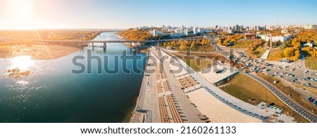 Bridge and busy city street leads along the embankment of a large river