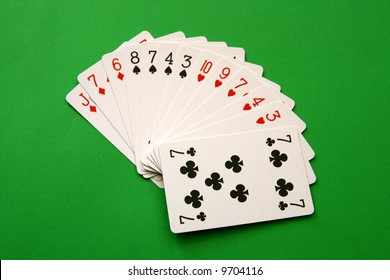 bridge cards - one hand (8,7,4,3 spades, 10,9,7,4,3 hearts, J,7,6 diamonds, 7 club)  background green,