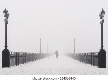 Bridge city landscape in foggy snowy winter day - alone woman, lanterns and doves flock - Ukraine, Donetsk - Powered by Shutterstock