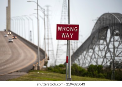 Bridge City, Texas, USA, - 2020: Wrong Way Road Sign. The Rainbow Bridge Crossing The Neches River In Southeast Texas. Dangerous Road, The Scariest Bridge In US. Cool Tourist Destination