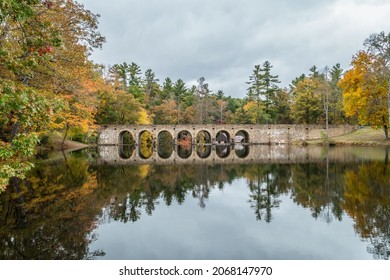 Bridge and colorful trees in autumn on a overcast cloudy sky a still reflection on Byrd lake in Tennessee at the state park