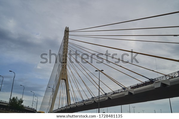 Bridge construction, bottom\
view. Cable stayed bridge construction on cloudy sky on\
background