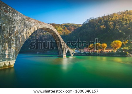 Bridge of the Devil or Ponte della Maddalena historic landmark in Garfagnana. Serchio river. Borgo a Mozzano, Lucca. Tuscany, Italy. Long Exposure in autumn.