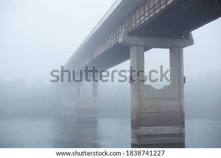 Bridge in fog, concrete bridge through river, bridgework between two banks of river, foggy sky, early morning. Stock foto © 
