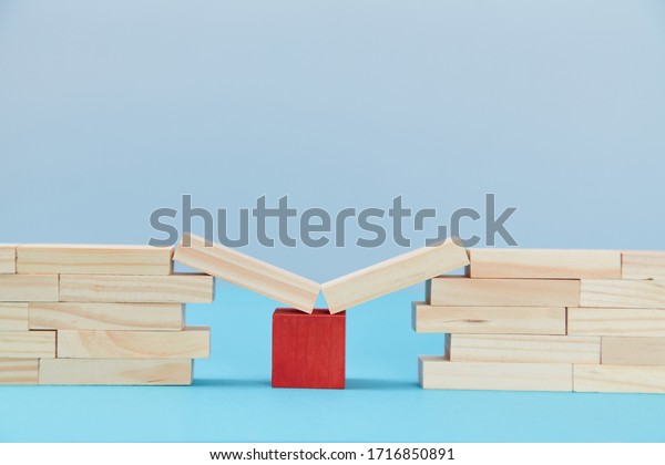 Bridge help.\
Safety net. Financial help. Business support. Wooden planks on red\
cube between bridge gap, copy\
space