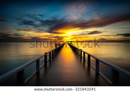 Bridge into the sea at sunset