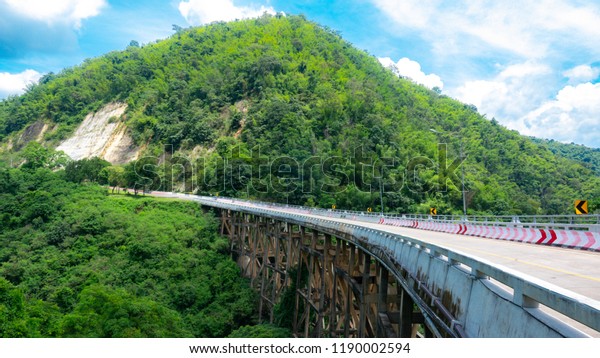Bridge in nature concept, big cement bridge\
on mountain on blue sky and white\
cloud