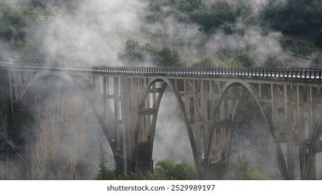 Bridge on the Tara River, early in the morning in the fog. Beautiful nature of the north of Montenegro and the Tara River Canyon.  - Powered by Shutterstock