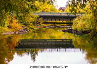 bridge over colorful river in city park in autumn, Whitefish, Montana