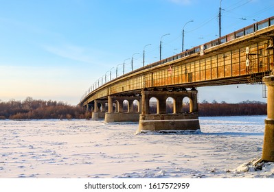 Bridge Over An Frozen River And A Blue Sky In Siberia In Russia. Irtych River In Omsk In Winter.