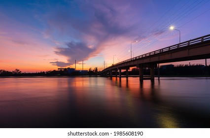 Bridge Over River In The Evening. The Light From The Lamp To The Reflector Surface,Container Terminal In Hamburg, Germany. Bridge Is Called Koehlbrandbruecke - A Bridge About The Harbor.