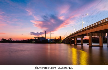 Bridge Over River In The Evening. The Light From The Lamp To The Reflector Surface,Container Terminal In Hamburg, Germany. Bridge Is Called Koehlbrandbruecke - A Bridge About The Harbor.