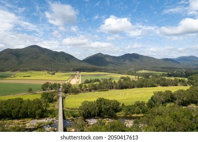 Bridge Over A Rocky Creek Amongst Fields Of Sugarcane And A Mountain Background Under A Cloudy Blue Sky. Highams Bridge, Finch Hatton, Mackay, Queensland, Australia