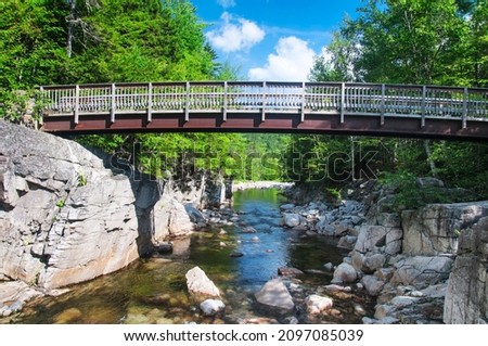 A bridge over the rocky gorge scenic area on kancamagus Highway on the swift river in Albany new hampshire on a sunny day.