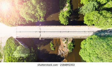 bridge over a small flat river on a sunny day view from a drone. High quality photo