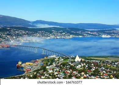 Bridge And Panorama Of City Tromso, Norway Beyond The Arctic Circle. View On Mountains In Norwegian Fjords.