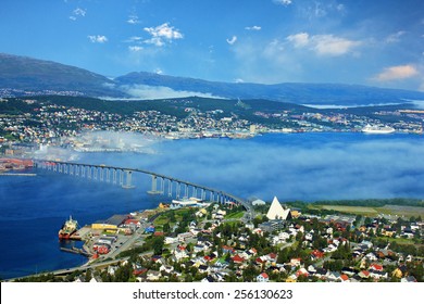 Bridge And Panorama Of City Tromso, Norway Beyond The Arctic Circle. View On Mountains In Norwegian Fjords